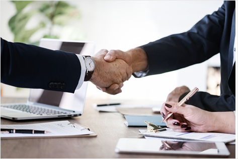 a professional business setting where two individuals are shaking hands
