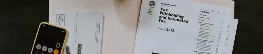 This image represents tax documents, a calculator, and financial paperwork